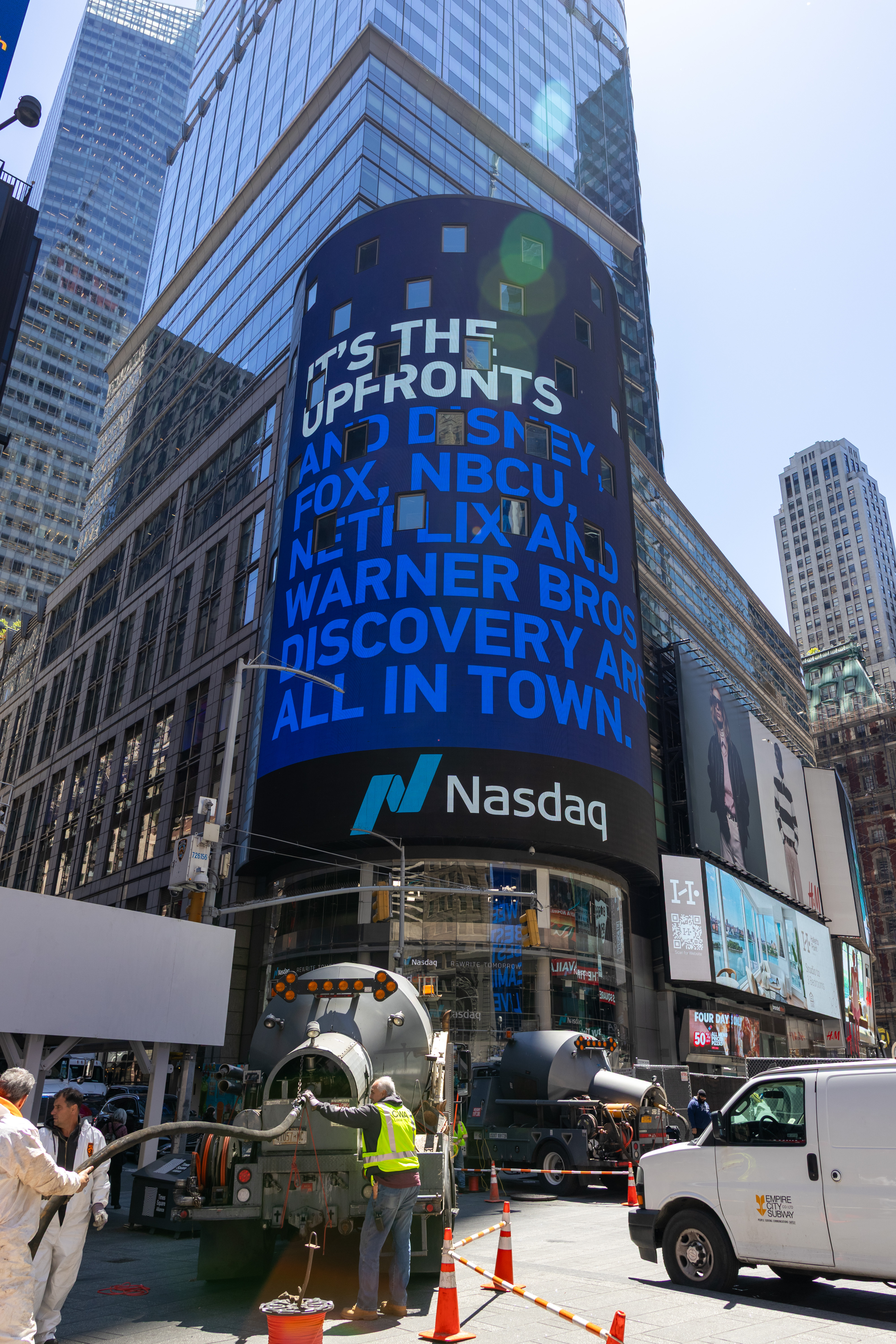 Exterior of the Nasdaq Tower in New York, photographed on May 12, 2026 during the TV network upfronts; the screen shows an unrelated advertising message
