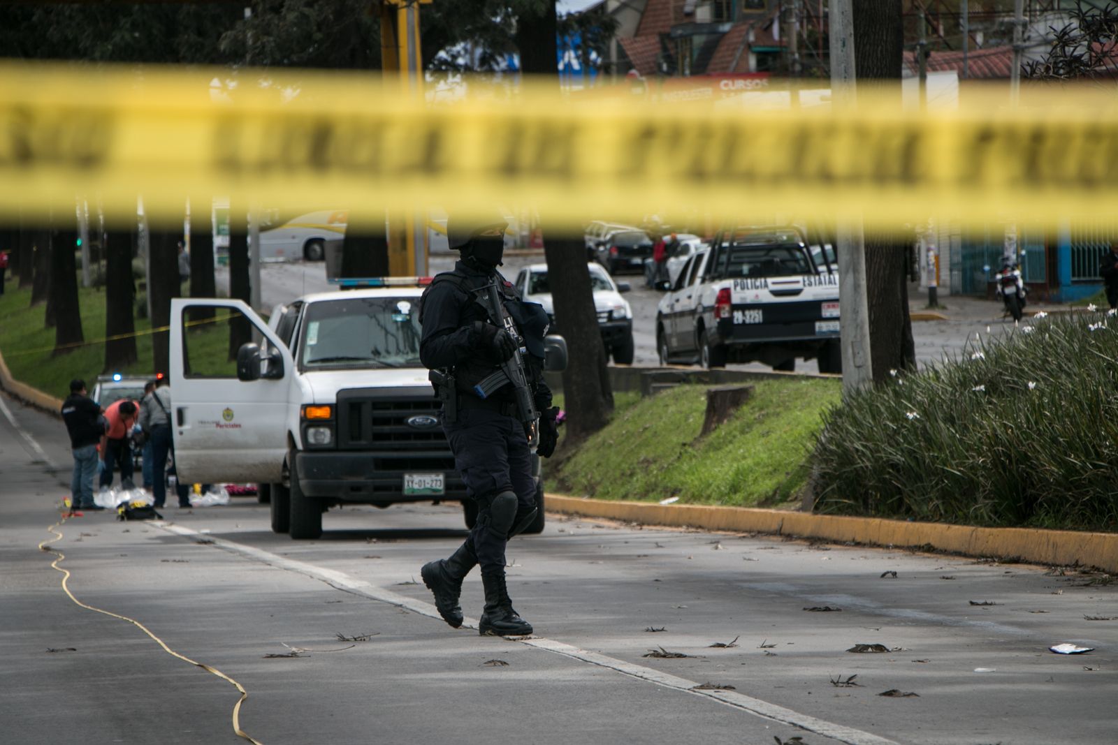 A masked, armed police officer at a cordoned-off street scene; illustrative stock photo, not an Axon camera or customer