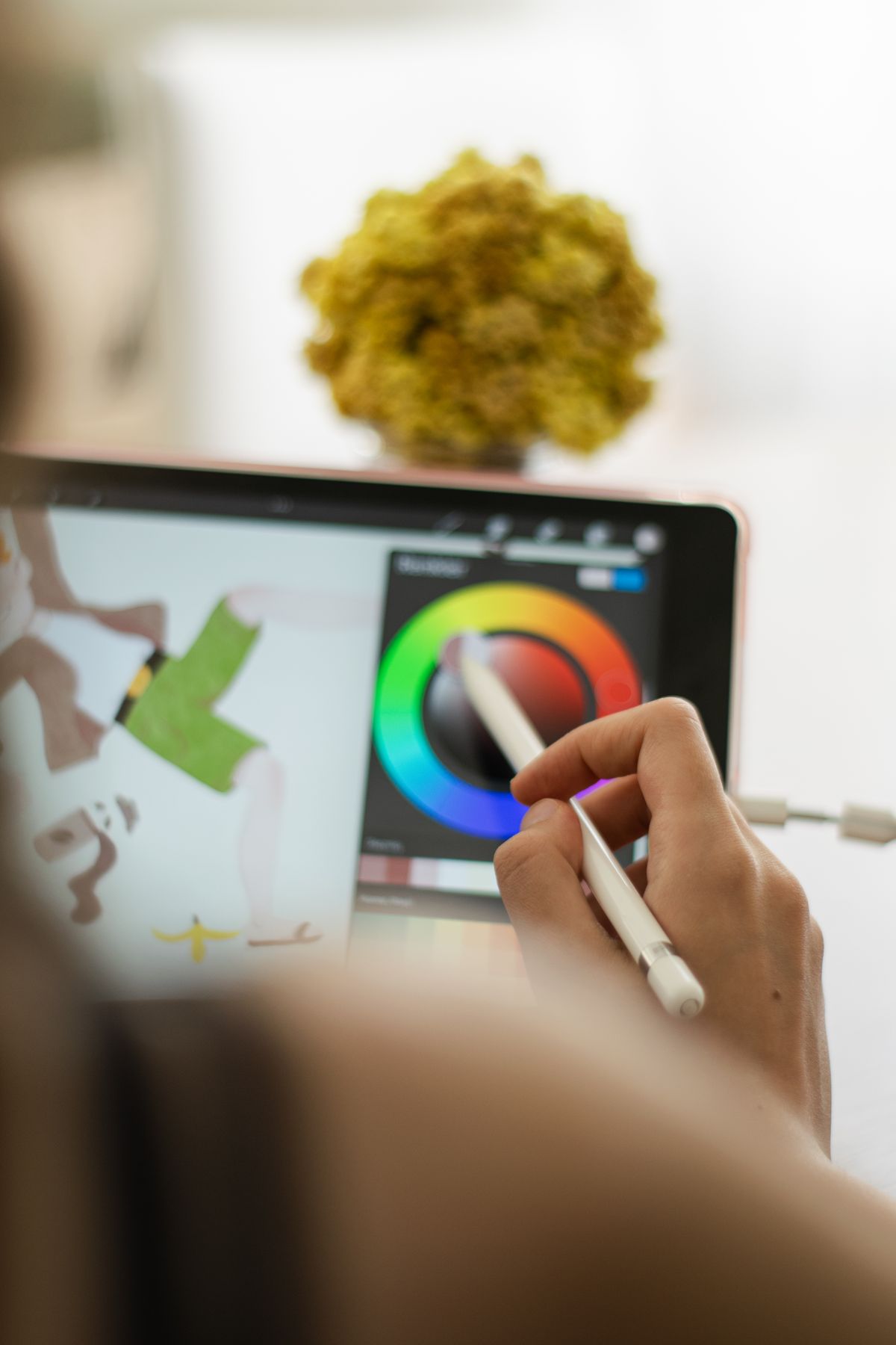 Close-up of a hand using a stylus on a digital drawing tablet for art creation