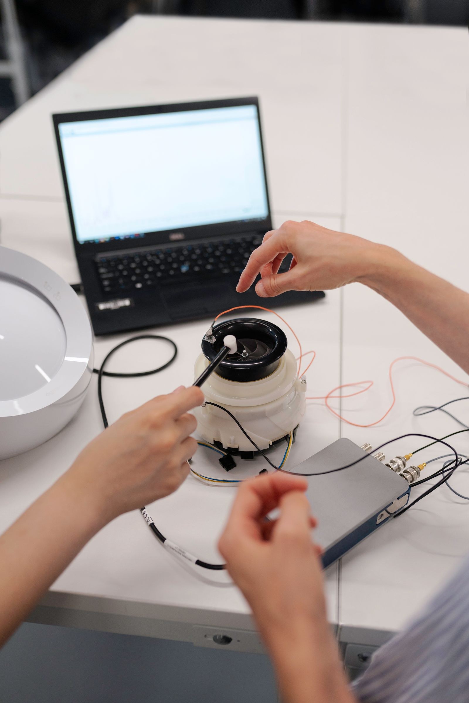 Engineers working on prototype testing with a laptop in a lab