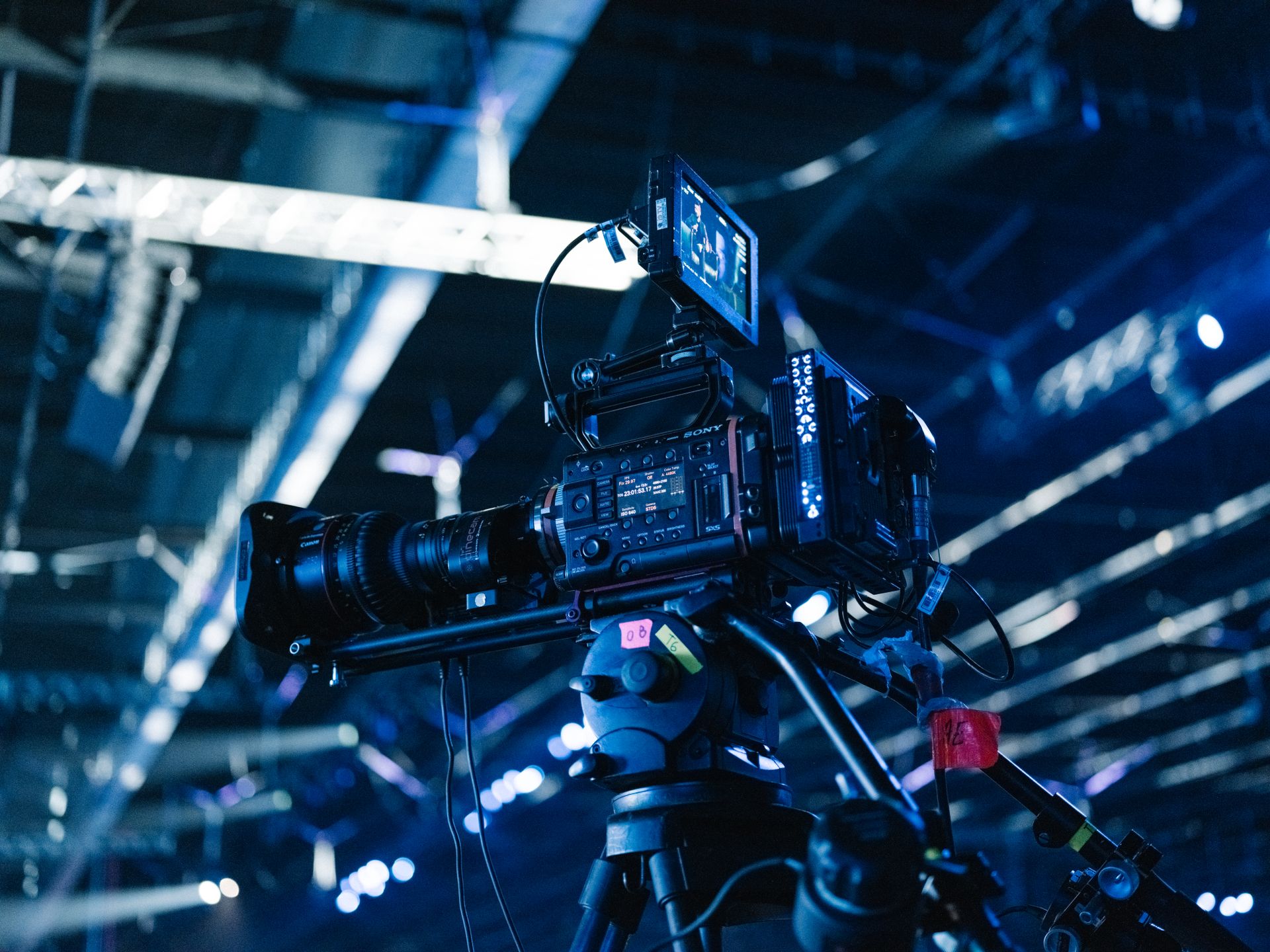 Close-up of a professional video camera setup in a well-lit indoor venue