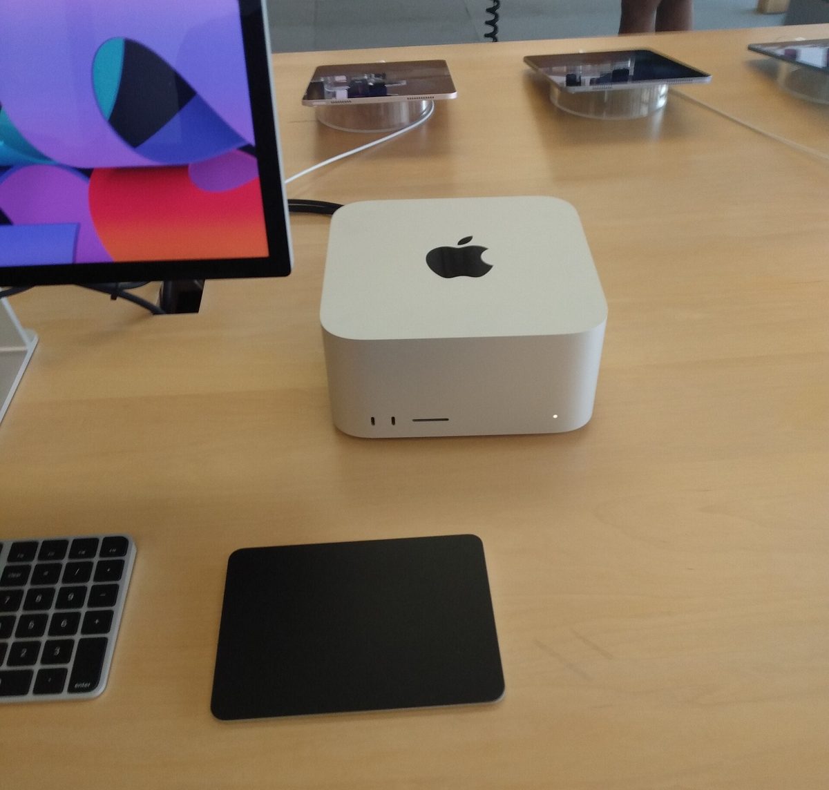 Apple Mac Studio with Studio Display, keyboard and trackpad on a desk in an Apple Store