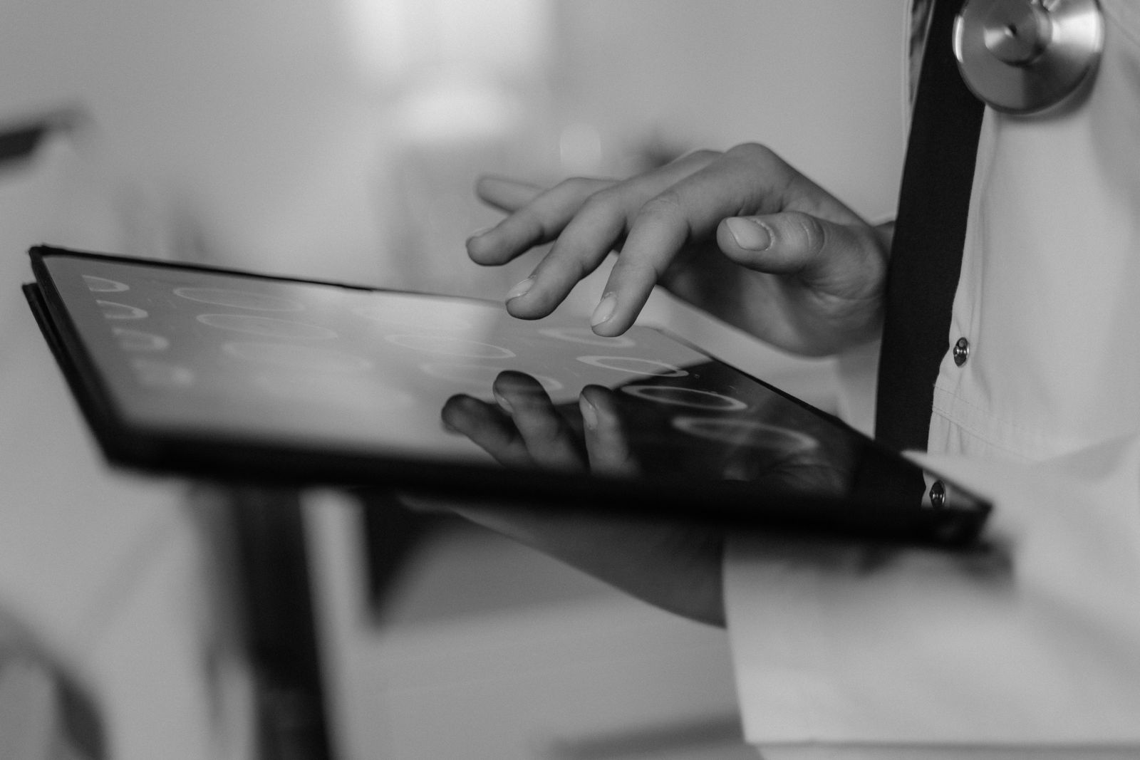 Close-up of a doctor's hand using a touchscreen tablet