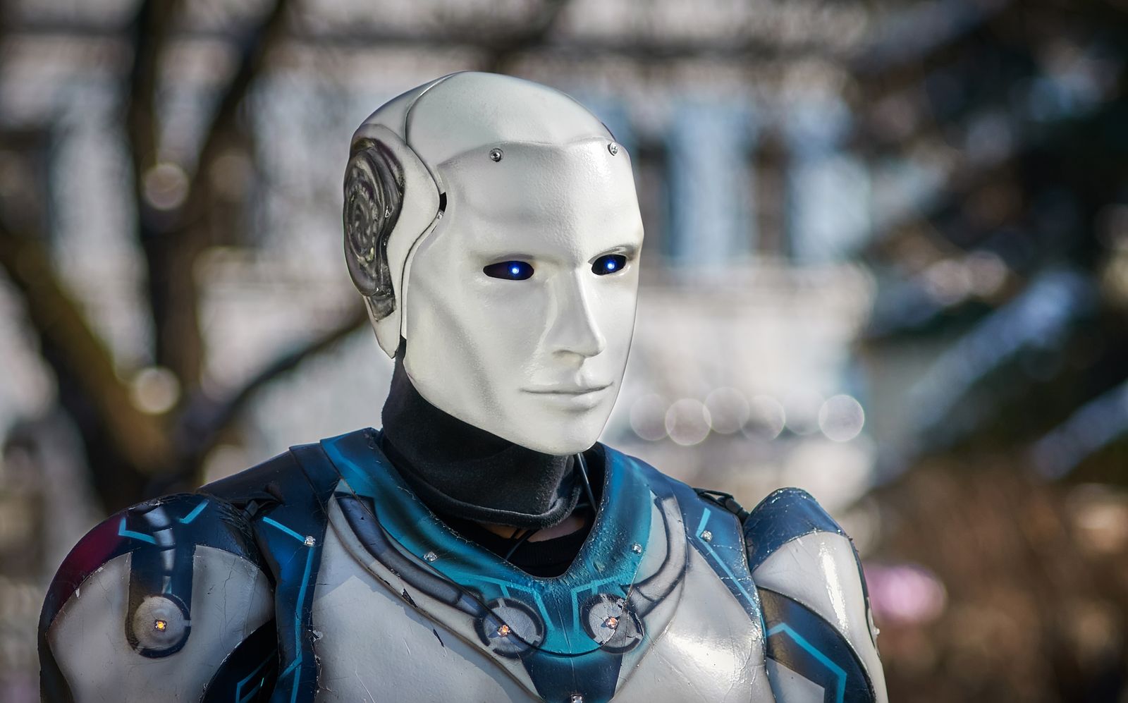 Close-up of a futuristic humanoid robot with metallic armor and blue LED eyes (stock photo)