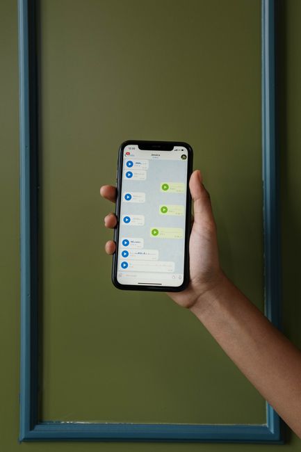 Hand holding a smartphone displaying a chat conversation