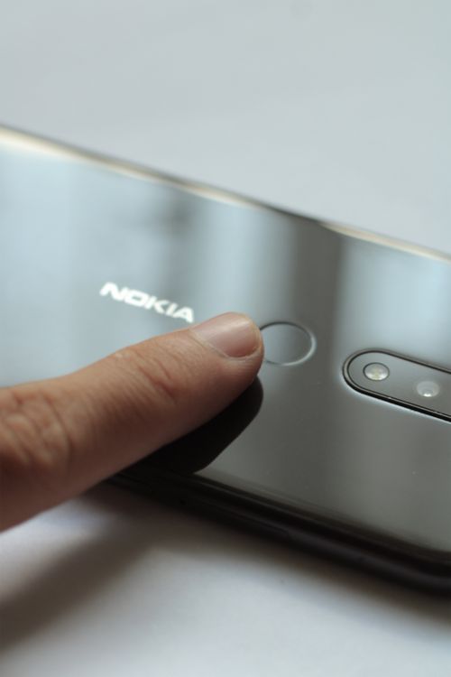 Close-up of a finger touching a smartphone's fingerprint scanner for secure access