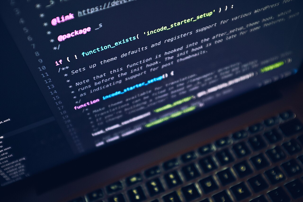 Close-up of a laptop screen showing syntax-highlighted code in a dark editor