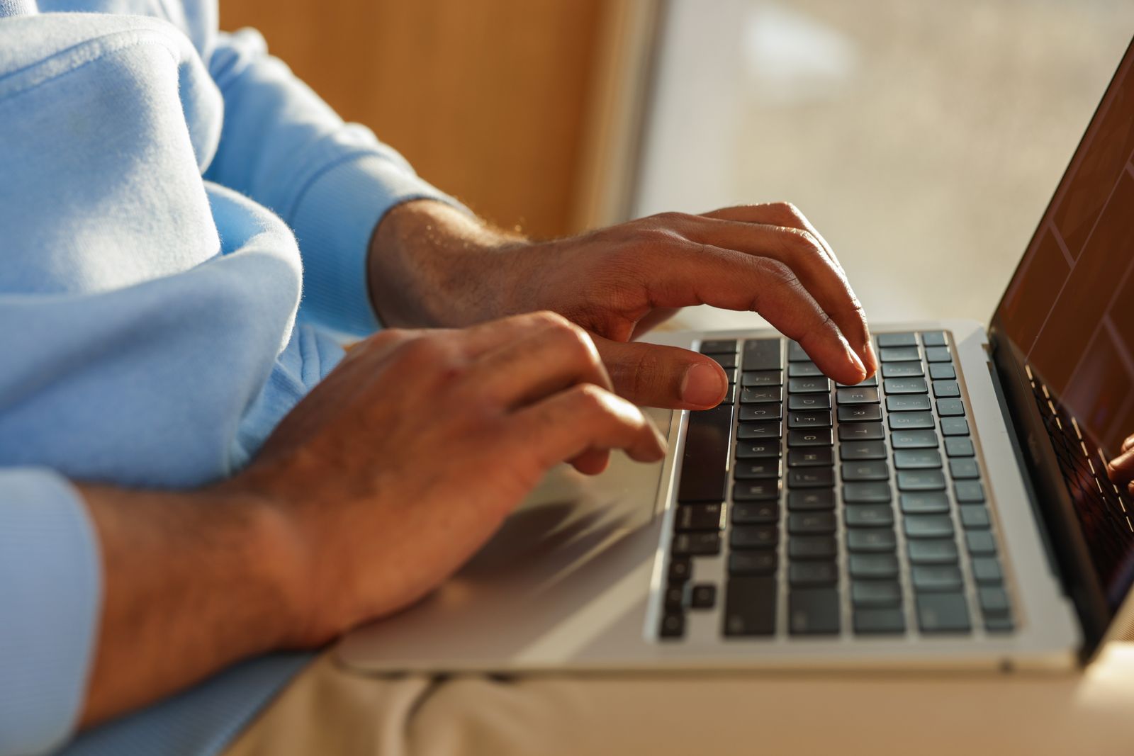 Close-up of hands typing on a laptop