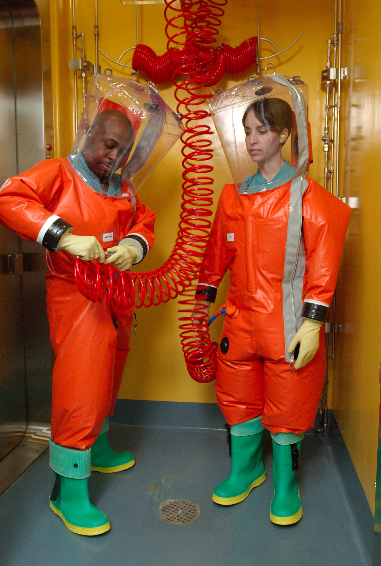 Two microbiologists in orange positive-pressure suits preparing to enter a biosafety level-4 laboratory
